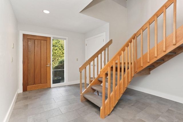 entryway with baseboards, recessed lighting, and stairs