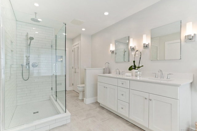 bathroom with a sink, double vanity, toilet, recessed lighting, and a shower stall