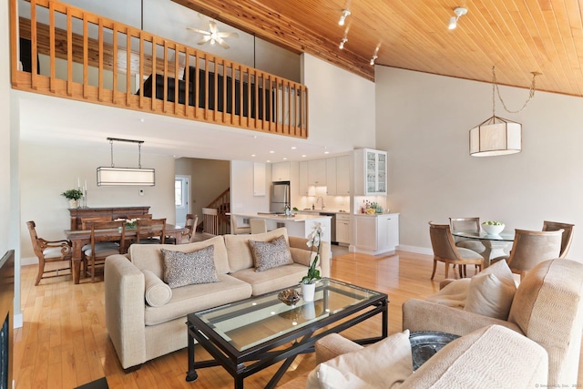 living room with baseboards, a high ceiling, wooden ceiling, and stairway