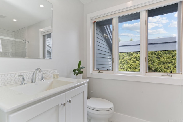 bathroom featuring toilet, recessed lighting, a healthy amount of sunlight, and vanity