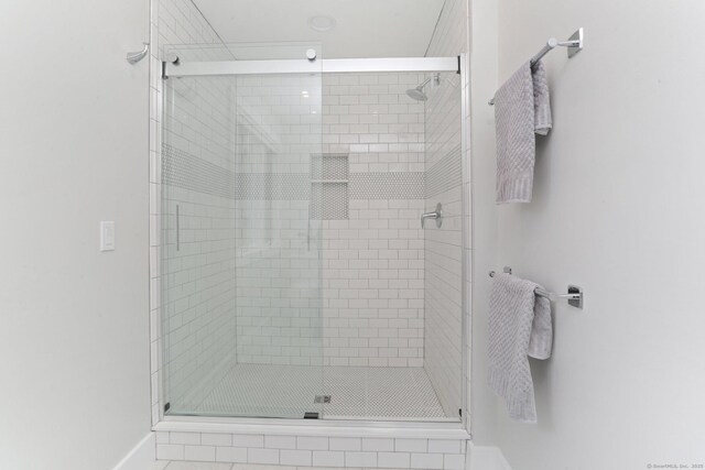 bathroom featuring baseboards and a stall shower