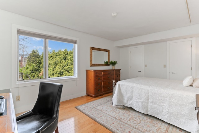 bedroom with light wood-style floors and baseboards