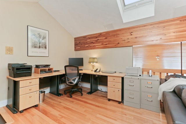 office space with light wood-style flooring and vaulted ceiling with skylight