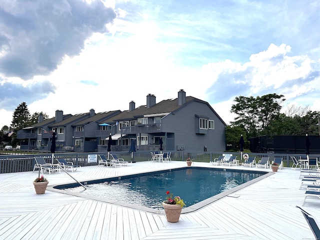 community pool with a patio area and fence