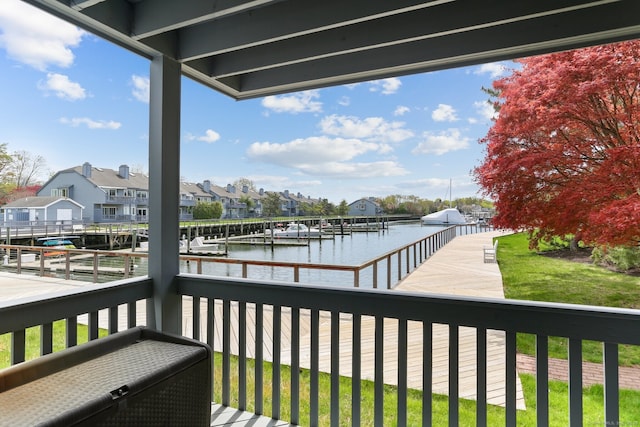 balcony featuring a residential view, a water view, and a dock