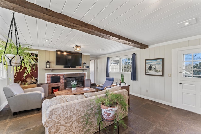 living room with baseboards, a healthy amount of sunlight, beam ceiling, and a fireplace