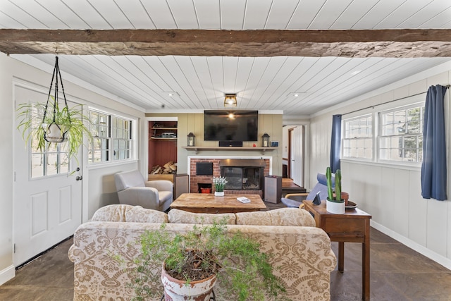 living area with wood ceiling, baseboards, beamed ceiling, and a fireplace