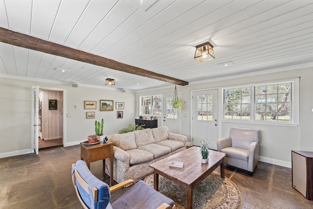 living area with baseboards, stone tile floors, and a healthy amount of sunlight