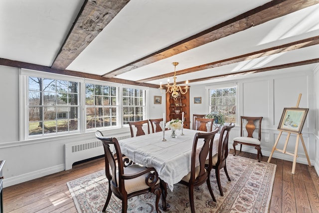 dining room featuring beamed ceiling, radiator heating unit, hardwood / wood-style flooring, and an inviting chandelier