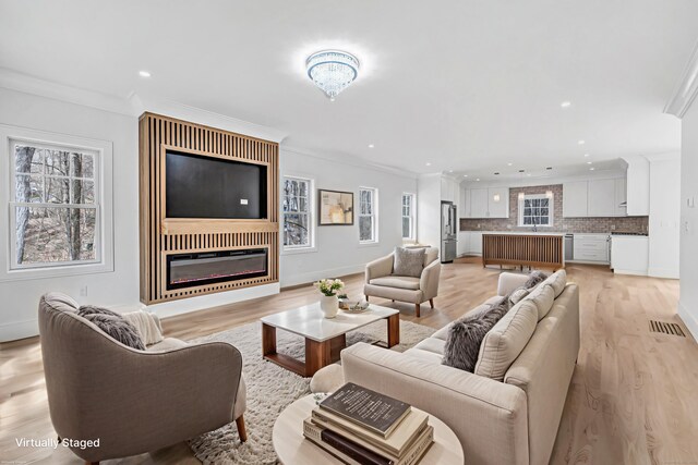 8 Fox Run, Monroe, CT 06468 - living room with ornamental molding, plenty of natural light, a glass covered fireplace, light wood-style floors, and recessed lighting