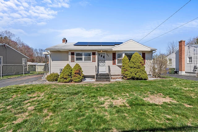 436 Brewer St, East Hartford, CT 06118 - bungalow-style house featuring a chimney, solar panels, aphalt driveway, and a front yard