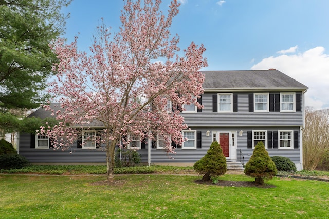 colonial-style house with a front lawn