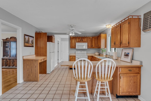 kitchen with light countertops, a ceiling fan, a sink, white appliances, and a peninsula