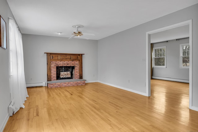 unfurnished living room featuring a baseboard radiator, a ceiling fan, a baseboard heating unit, light wood-type flooring, and a fireplace