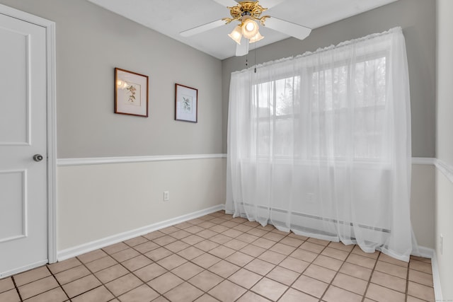 spare room with baseboards, a ceiling fan, and light tile patterned floors