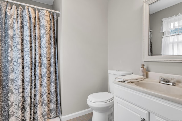 bathroom with curtained shower, tile patterned flooring, toilet, vanity, and baseboards