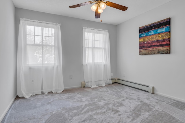 carpeted empty room with a baseboard radiator, baseboards, and ceiling fan