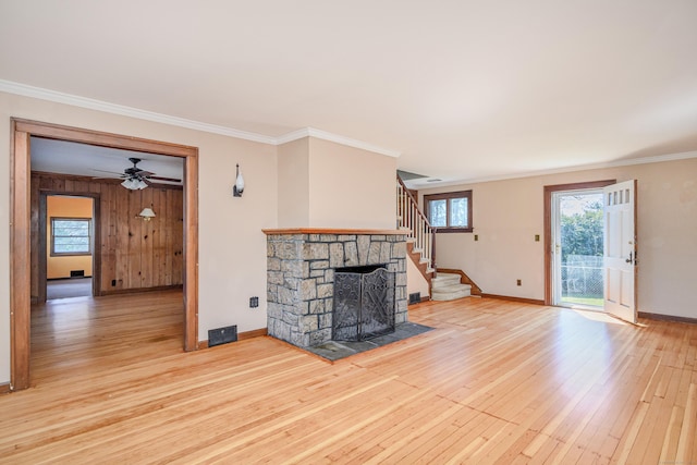 unfurnished living room featuring baseboards, visible vents, stairway, crown molding, and hardwood / wood-style flooring