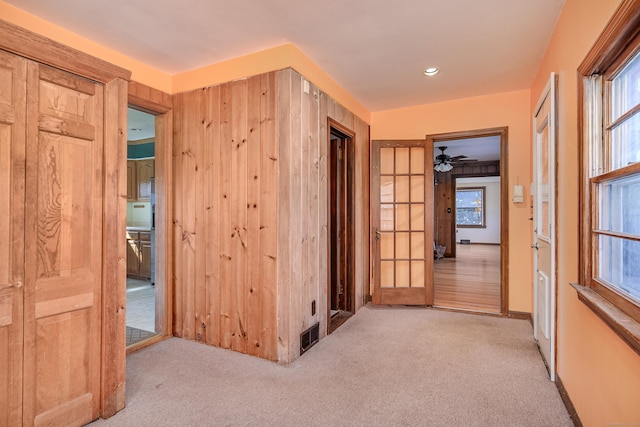 hallway with carpet flooring, visible vents, and plenty of natural light