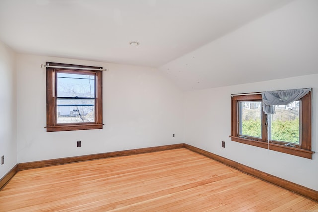 bonus room with baseboards, plenty of natural light, lofted ceiling, and hardwood / wood-style flooring
