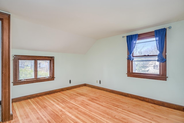 bonus room featuring lofted ceiling, plenty of natural light, hardwood / wood-style flooring, and baseboards