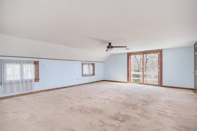 bonus room with lofted ceiling, a ceiling fan, baseboards, and a wealth of natural light