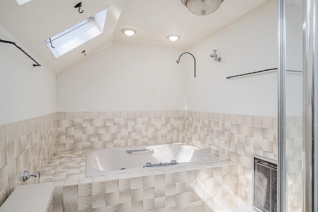 bathroom featuring vaulted ceiling with skylight, a bath, and heating unit