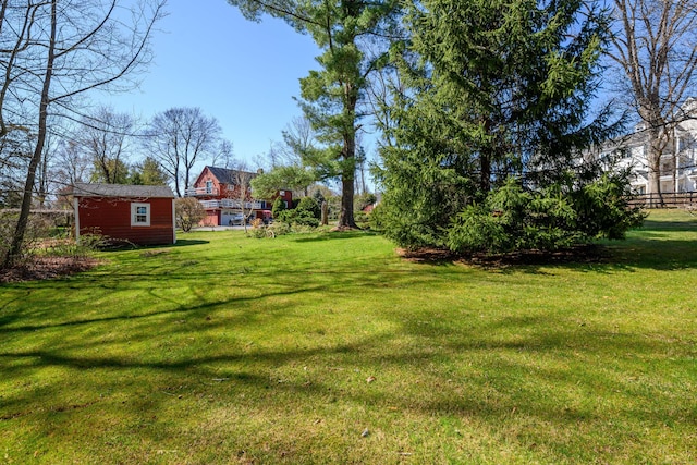 view of yard featuring an outdoor structure and fence