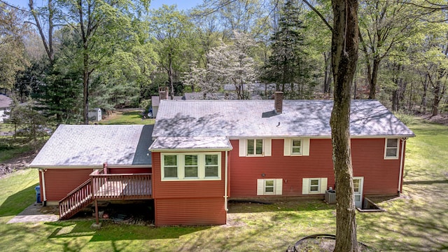 rear view of house with a lawn, stairs, a chimney, and a deck