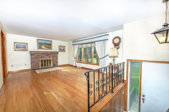 living room featuring baseboards, visible vents, wood finished floors, and a fireplace