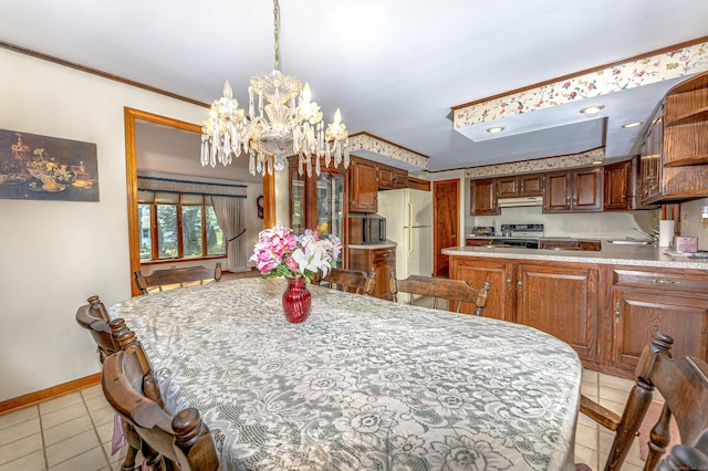 dining room featuring light tile patterned flooring, baseboards, an inviting chandelier, and ornamental molding