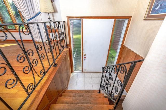 staircase with baseboards, tile patterned flooring, and wallpapered walls