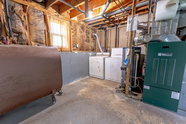 below grade area featuring heating unit, heating fuel, and washing machine and clothes dryer
