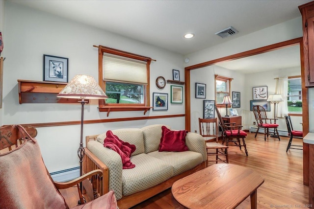 living room with baseboard heating, recessed lighting, and wood finished floors