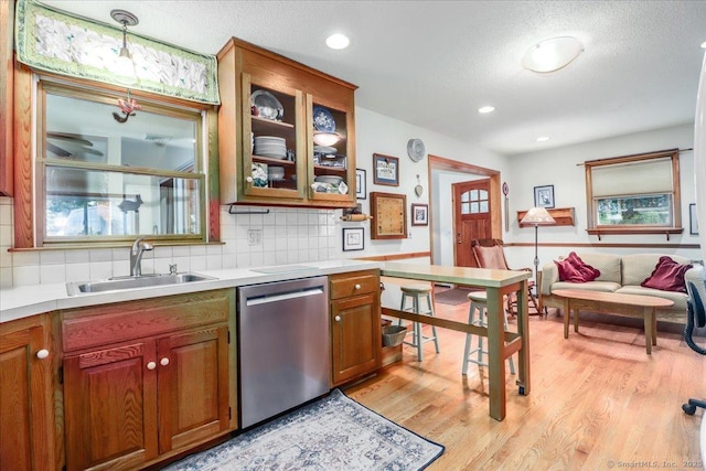 kitchen with dishwasher, a sink, light wood-style floors, light countertops, and recessed lighting