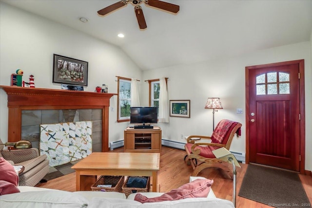 living area with a baseboard radiator, a baseboard heating unit, plenty of natural light, ceiling fan, and vaulted ceiling