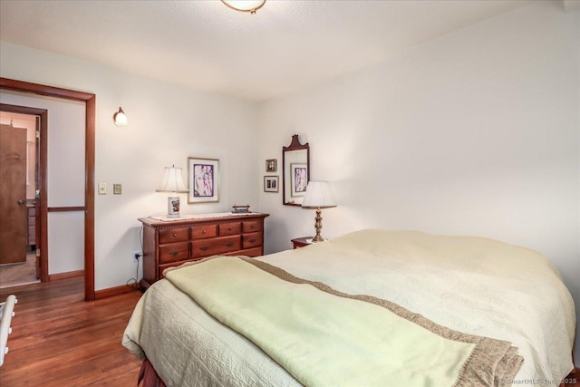bedroom with wood finished floors and baseboards