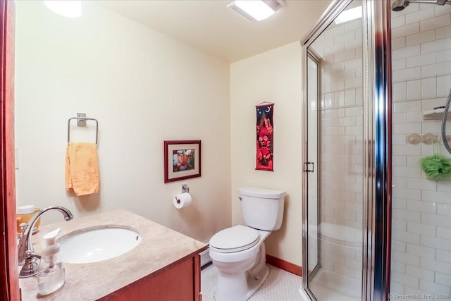 bathroom with a shower stall, vanity, toilet, baseboards, and tile patterned flooring