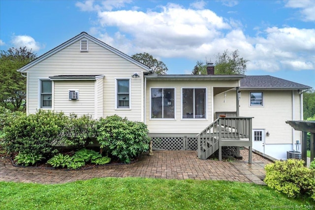 back of property featuring a patio area, a chimney, and cooling unit