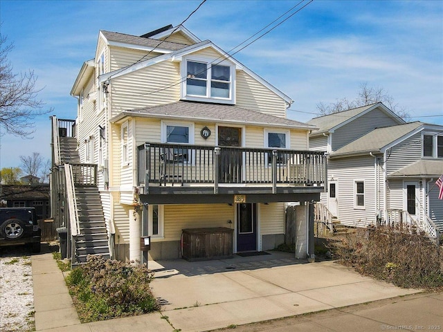 view of front of house with a deck, stairs, and a jacuzzi