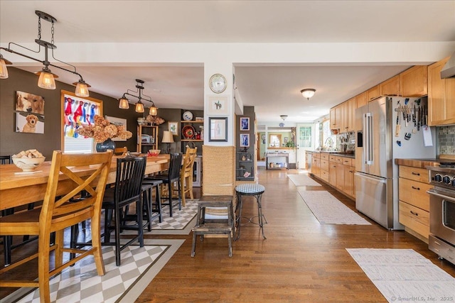 kitchen with dark countertops, high quality appliances, and dark wood finished floors