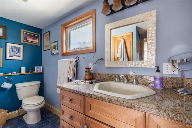 bathroom with tile patterned floors, vanity, toilet, and baseboards