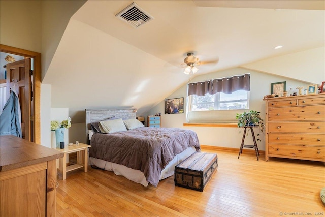 bedroom with baseboards, visible vents, lofted ceiling, and light wood finished floors