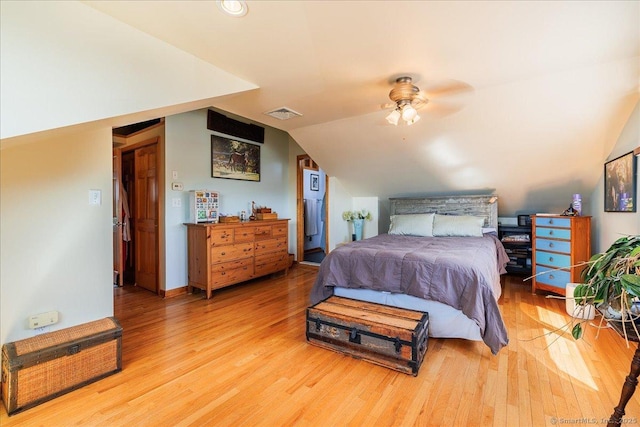 bedroom featuring a ceiling fan, visible vents, wood finished floors, and lofted ceiling