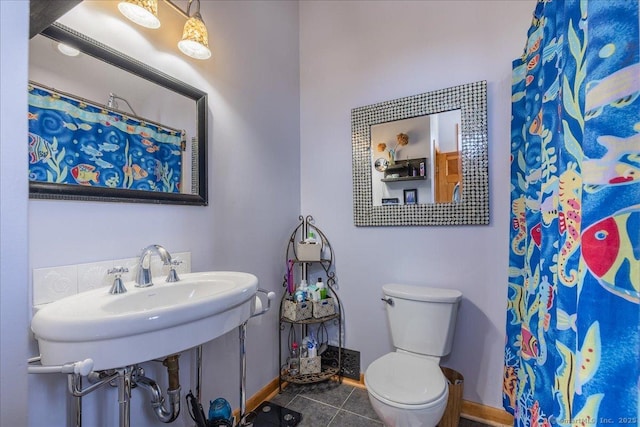 full bathroom featuring a sink, curtained shower, tile patterned floors, toilet, and baseboards