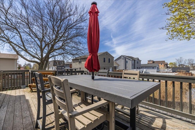 wooden terrace featuring outdoor dining area and a residential view