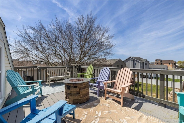 wooden terrace with a fire pit and a residential view