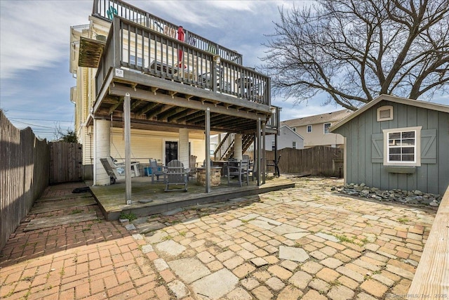 rear view of property with a deck, a patio area, and a fenced backyard