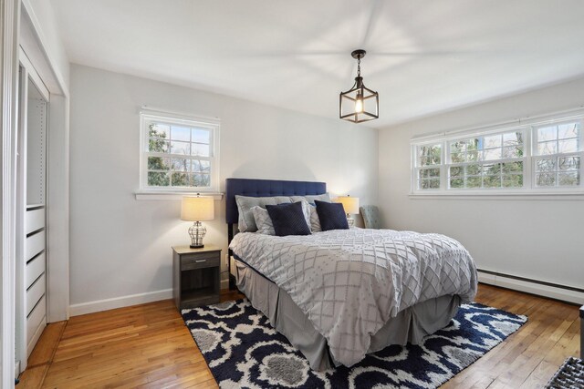 42 Stonecrop Rd, Norwalk, CT 06851 - bedroom with a baseboard radiator, light wood-style floors, baseboards, and multiple windows