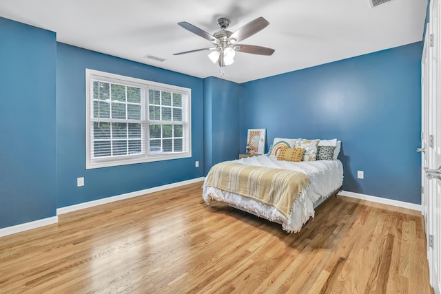 bedroom featuring wood finished floors, baseboards, and ceiling fan